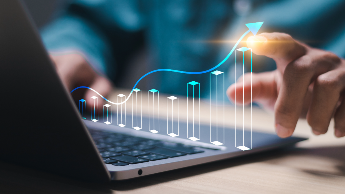 A close-up of a hand interacting with a rising digital graph on a laptop, symbolizing data-driven decision-making, business growth, and strategic B2B sales techniques.